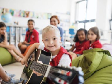 Kids in a class room holding a guitar