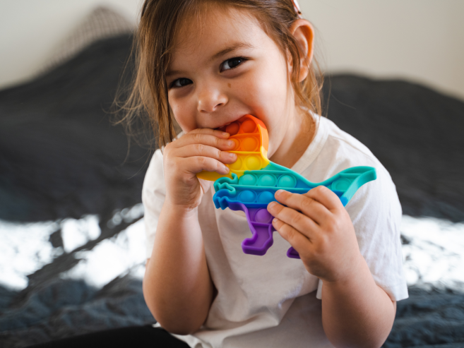 Autistic child with sensory toy in their mouth