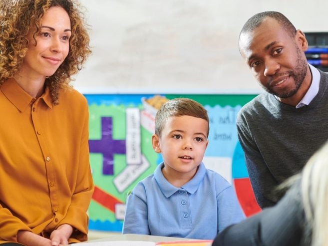 Family including young child at parent teacher meeting