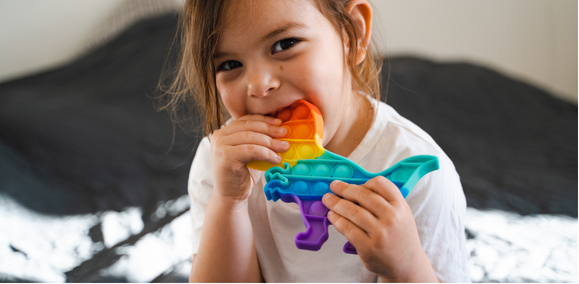 Young child with sensory chewy in their mouth