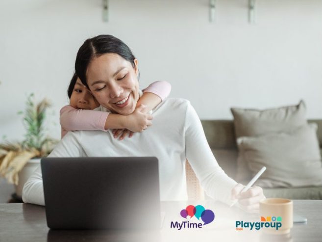Mother in front of a laptop with a child at the back