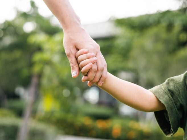 Adult and child holding hands